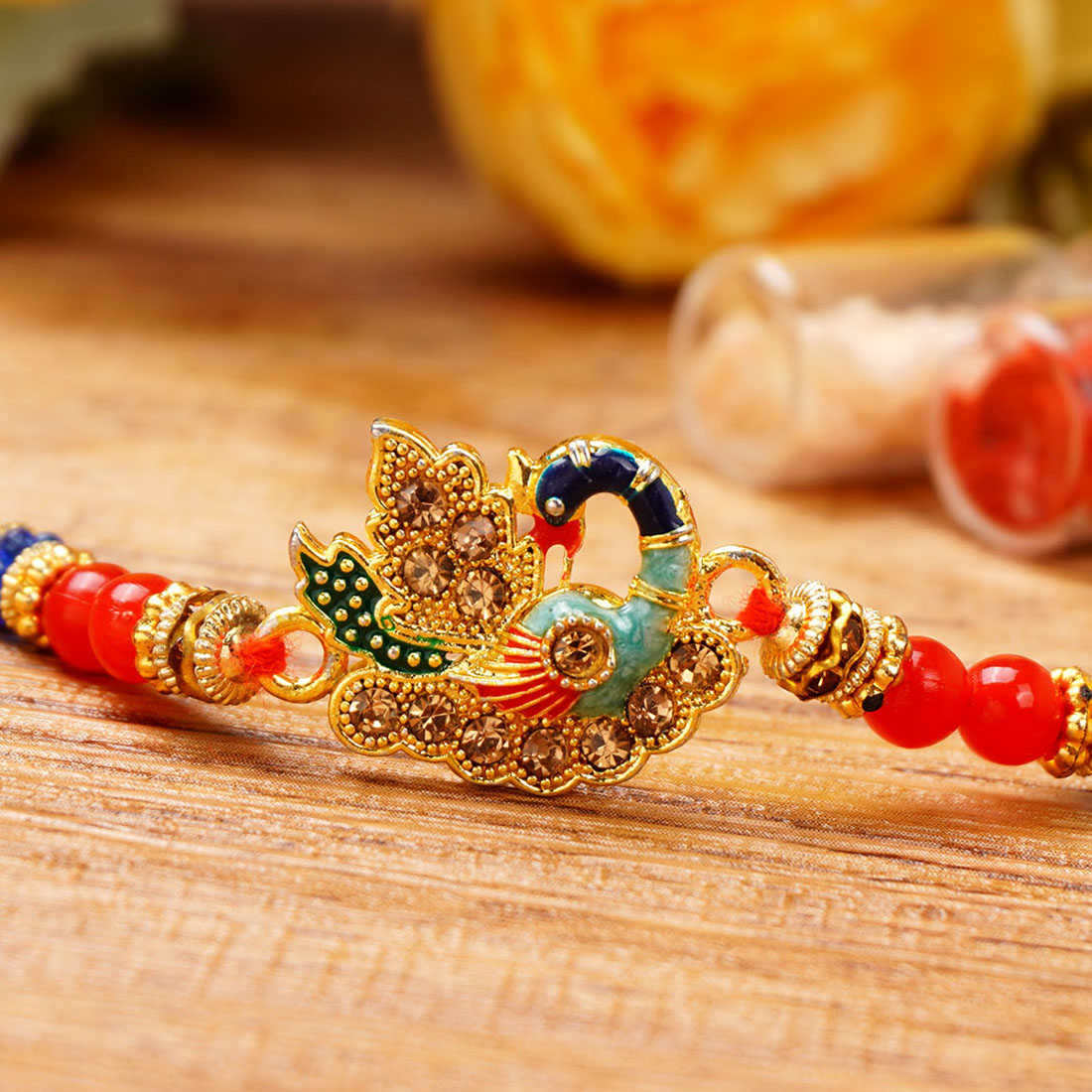 Urmika Colorful Peacock Rakhi with Red Thread with Roli Chawal