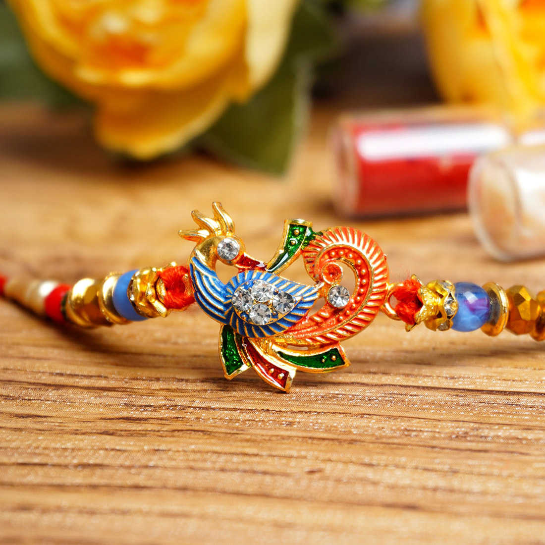 Urmika Peacock Rakhi with Red Thread with Roli Chawal